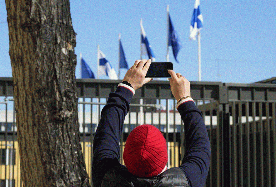 Muž fotografuje vlajky NATO a Finska Muž fotografuje vlajky NATO a Finska - 42TČen